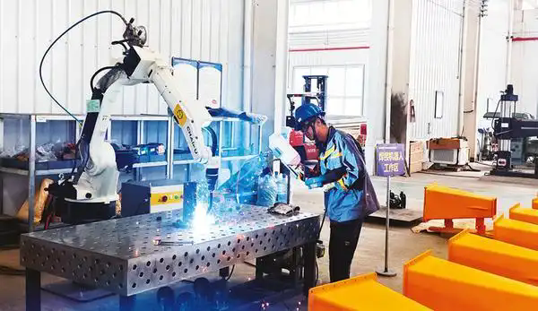 工人操作機(jī)器人焊接礦山機(jī)械零部件